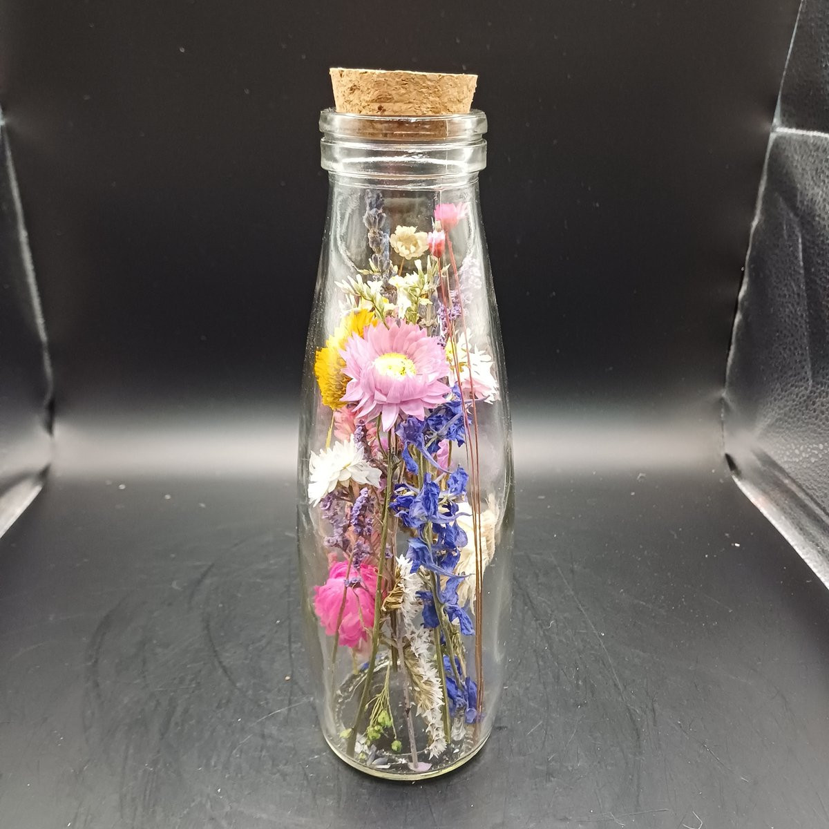 Decoratief boeket van droogbloemen in een glazen fles met kurk