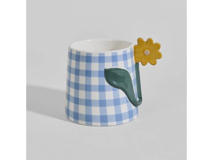 Steingutbecher mit blau-weiß kariertem Muster und Blumenhenkel