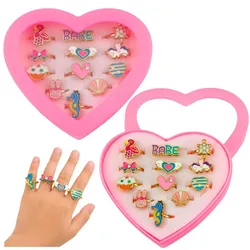 Set mit 12 verstellbaren Kinderringen aus Metall mit verschiedenen Herzmustern.