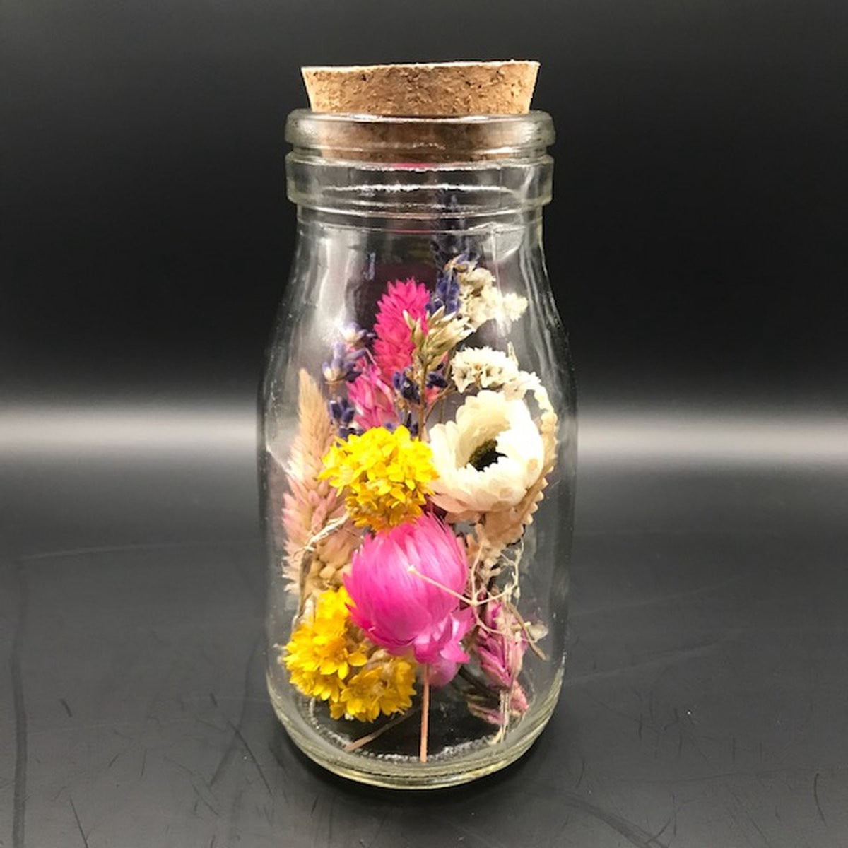 Decoratief boeket van droogbloemen in een glazen flesje met kurk