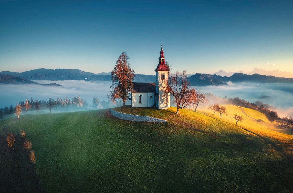 Fototapete PAPERMOON "PANORAMA-KIRCHE SONNE GEBIRGE LANDSCHAFT SLOWENIEN XXL", bunt, B:5m L:2,8m, Vlies, Tapeten, Fototapete bunt B/L: 5m x 2,8m, Bahnen: 10 Stk.