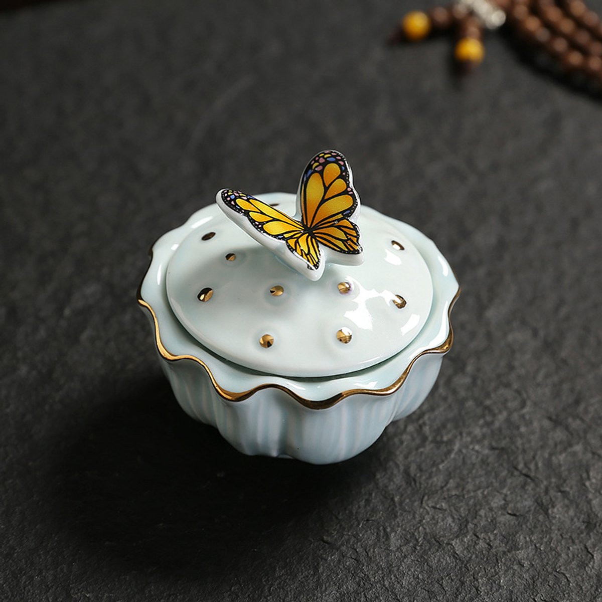 Miniatuur urn met vlindermotief in lichtblauw keramiek