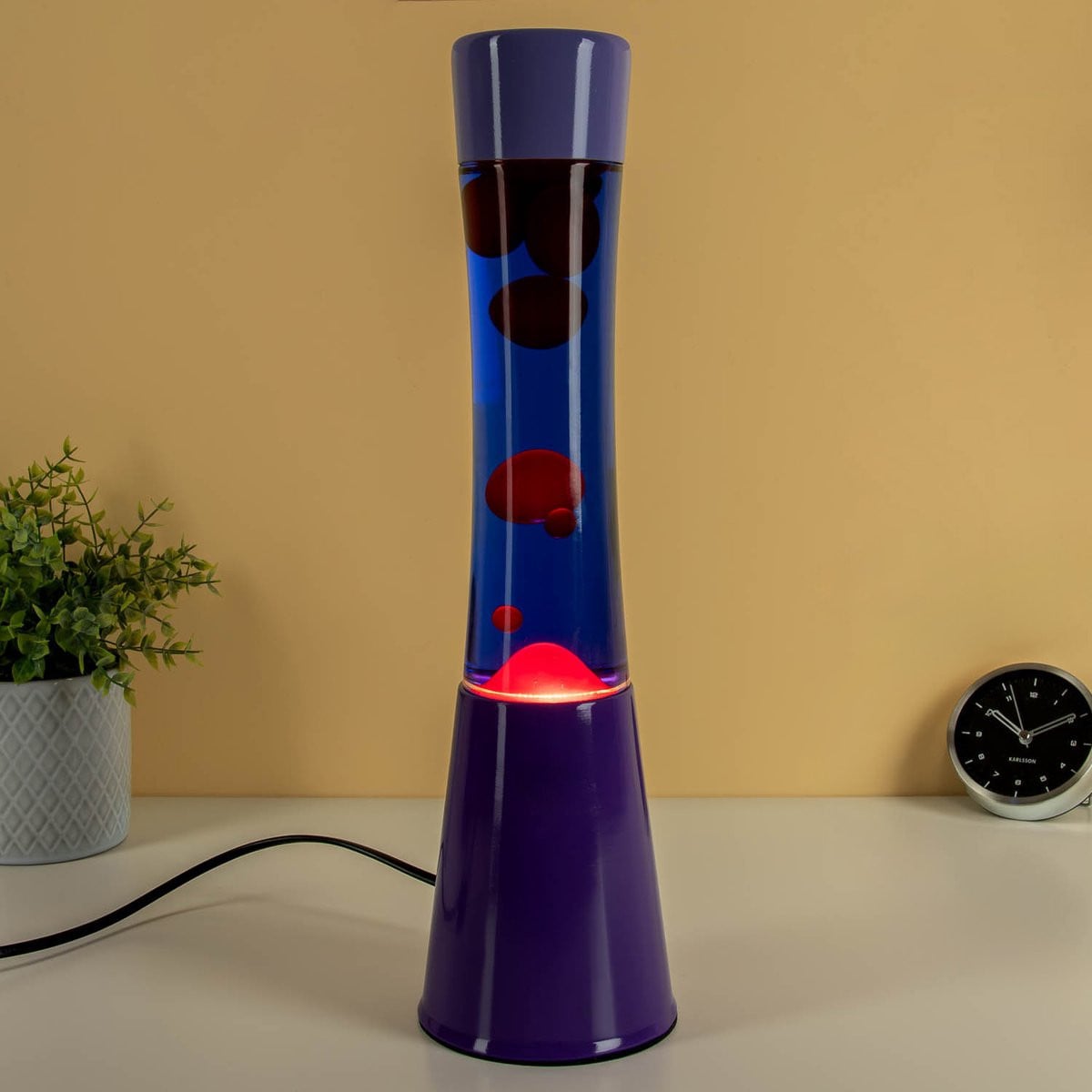 Fisura Lava Lamp met blauwe vloeistof, rode lava en purperen voet