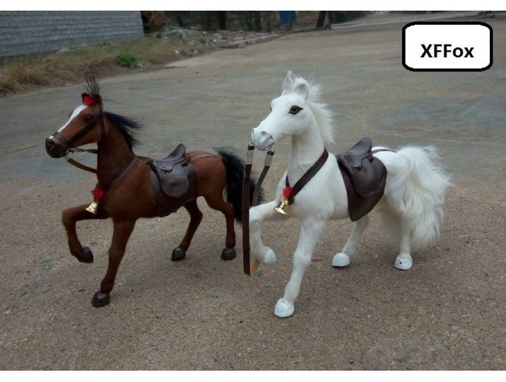 Une paire de modèles de chevaux blancs et bruns réalistes, en plastique et fourrure, avec selles, en forme de cheval simulé, en forme de cheval en plastique et fourrure, avec selles, en forme de