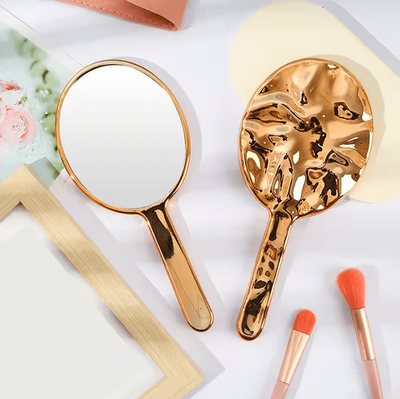Inspire Curations Liquid Ellipsoid Handheld Desktop Makeup Mirror rose Gold