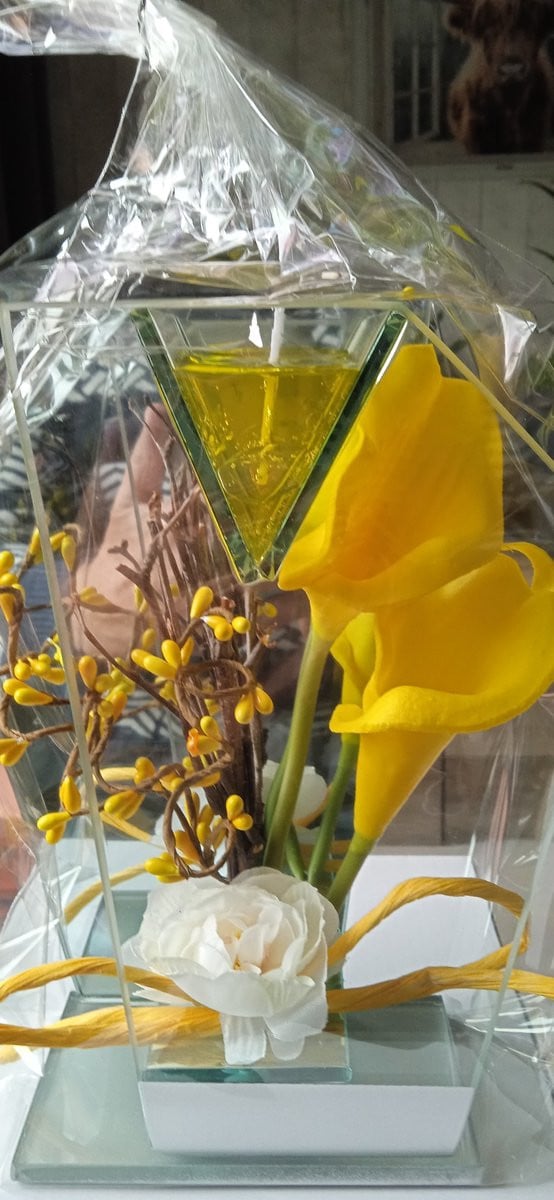 Glasdecoratie met gele bloemen en gelei lichtje