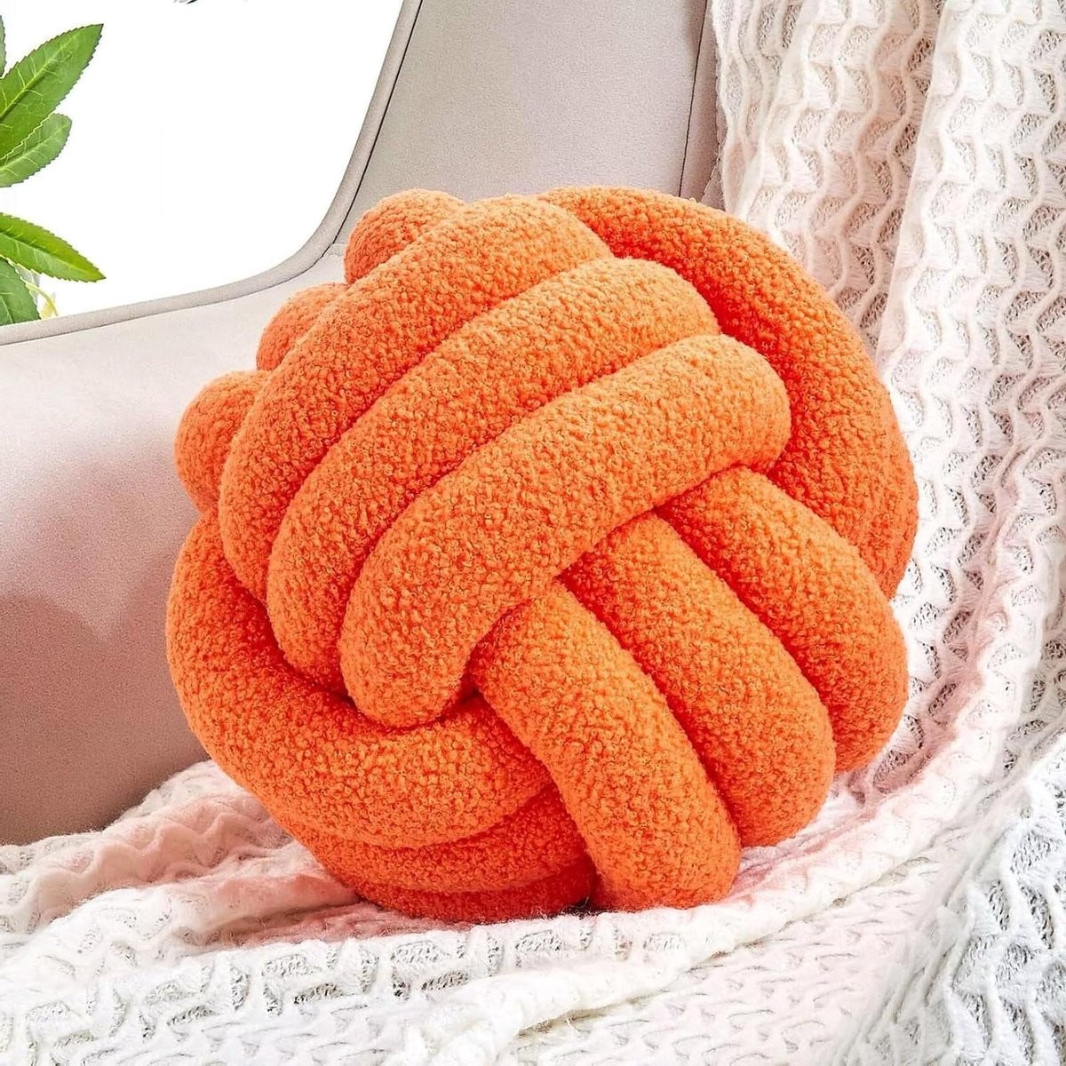 Rond decoratief knoopkussen in oranje met handgeknoopt stofontwerp