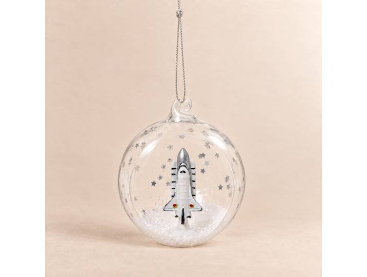 Weihnachtskugel aus durchsichtigem Glas und weiße Rakete