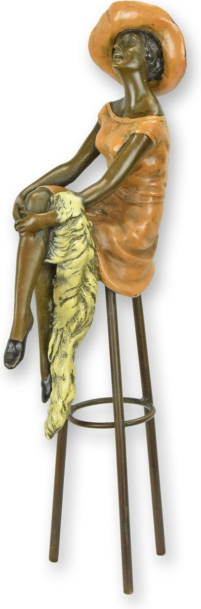Bronzen beeld van een poserende vrouw op een kruk voor op tafel